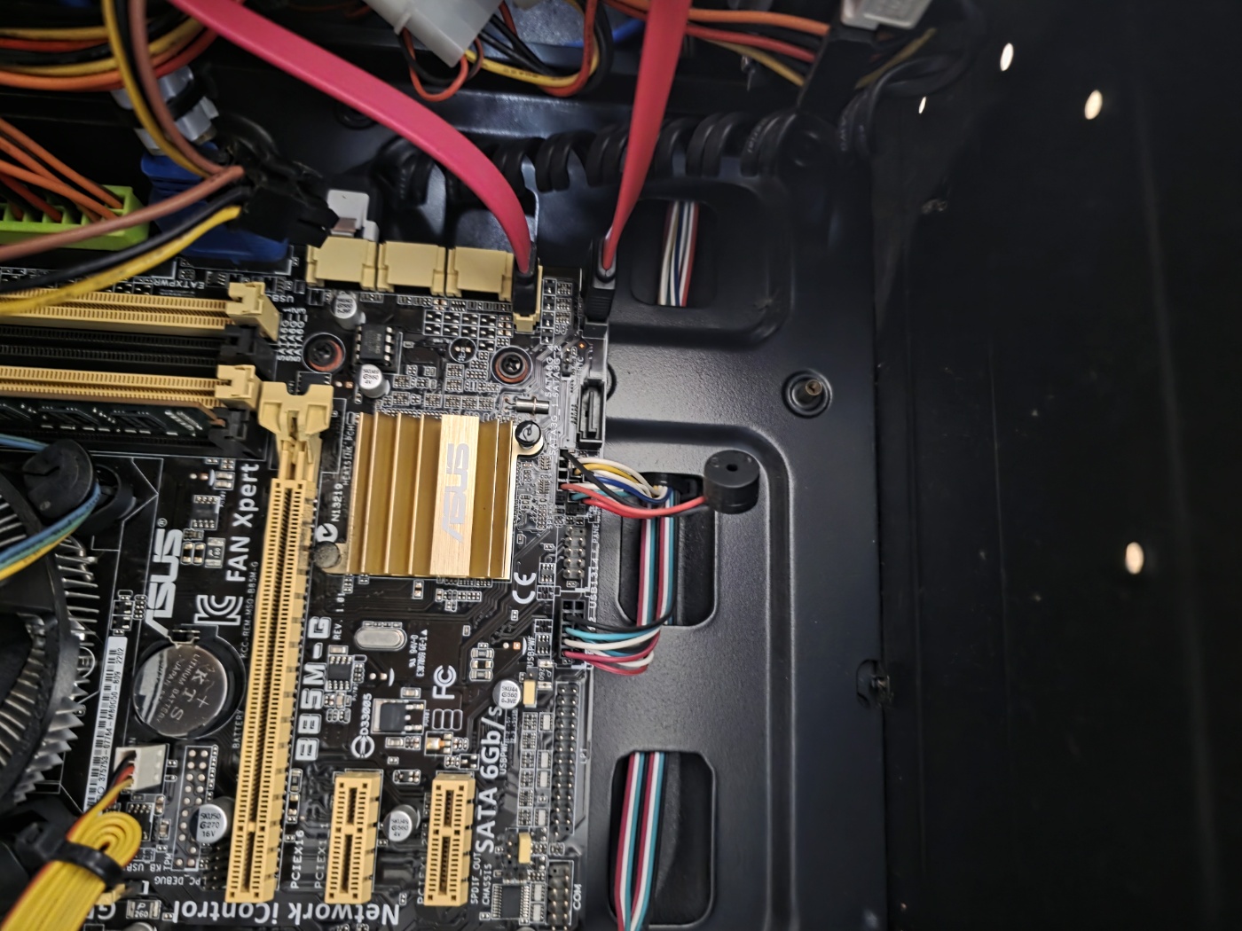 ASUS B85M-G 메인보드 클로즈업 — SATA 6Gb/s 포트와 DDR3 슬롯.